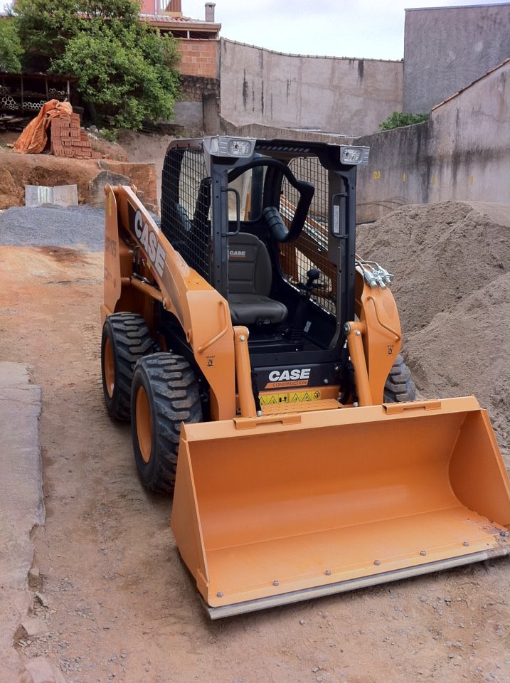 Máquina carregadeira amarela no pátio da Gato Neves, usada para carregar os caminhões de entrega